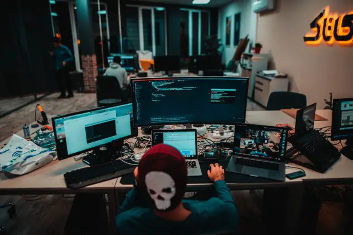 Schreibtisch mit vielen Monitoren und Laptops im Büro